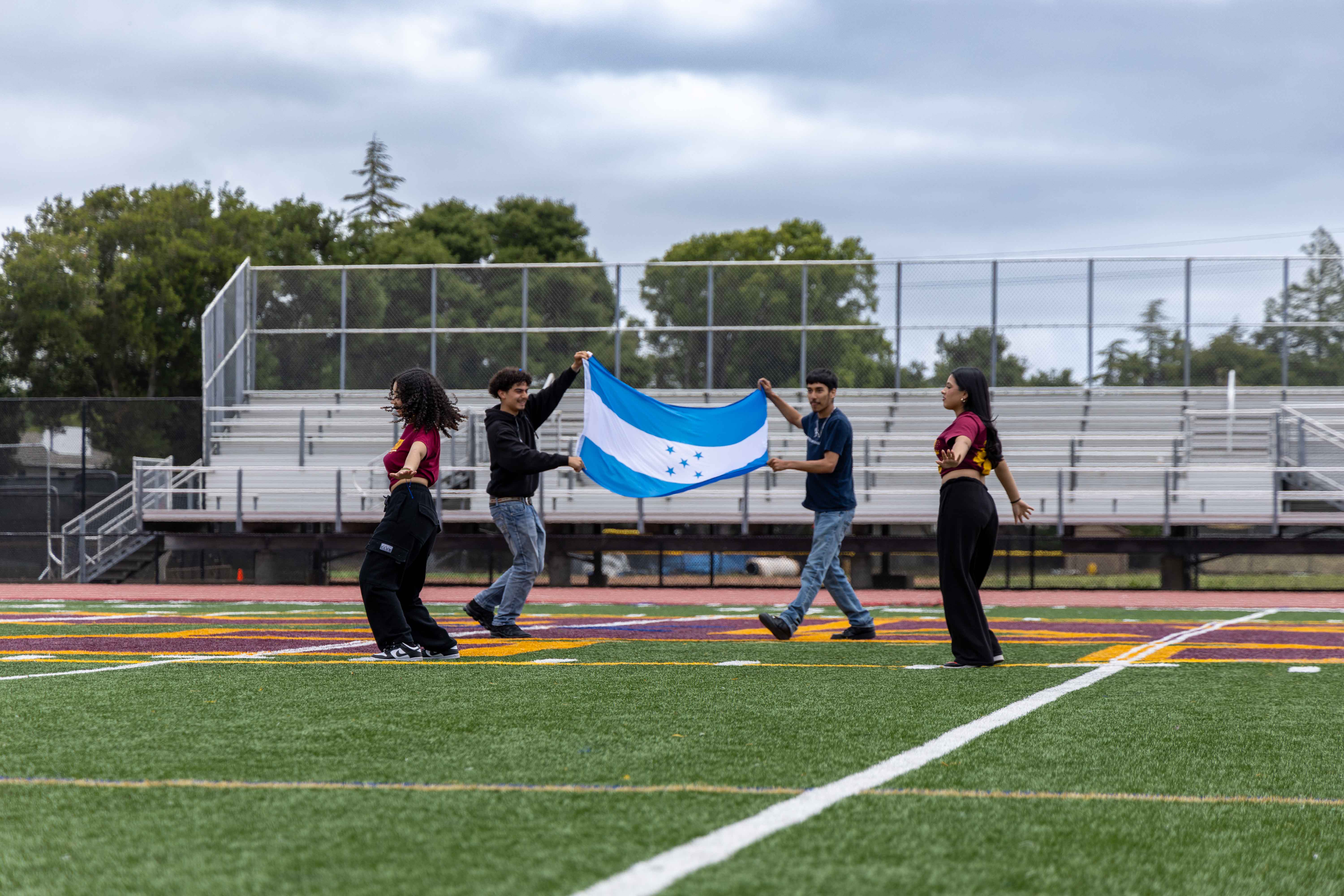 Baile Hispano waves Honduras flag while dancing.