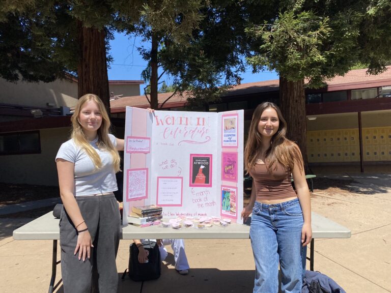 Junior Kim Pols and Schmidt show off their Female Authors and Feminist Themes book club display.