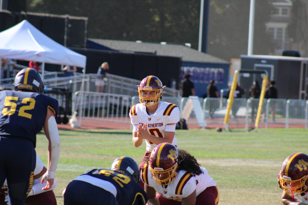 Junior quarterback Teddy Dacey hiking the ball.